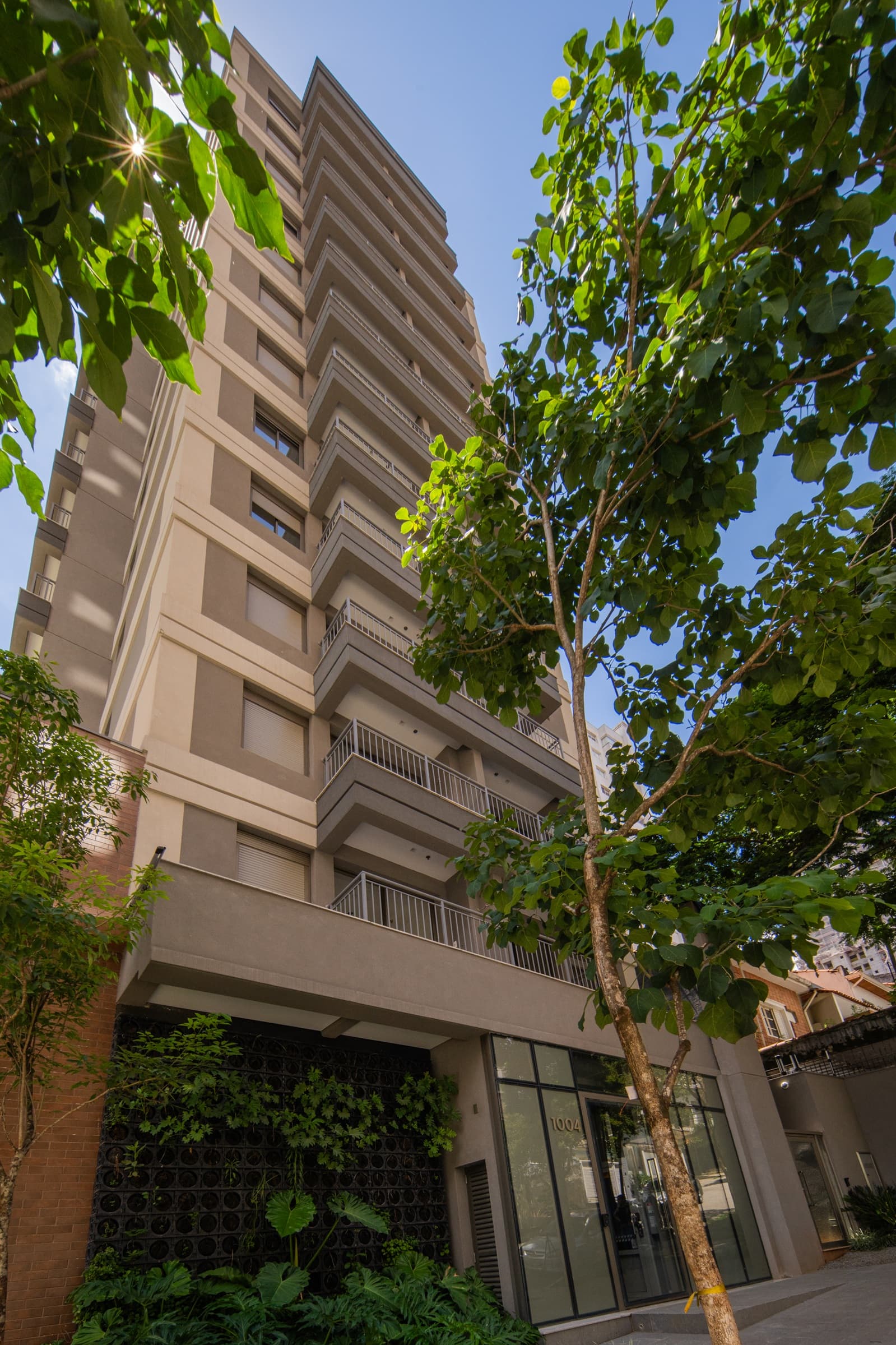 Vista externa da fachada principal do predio com vegetacao