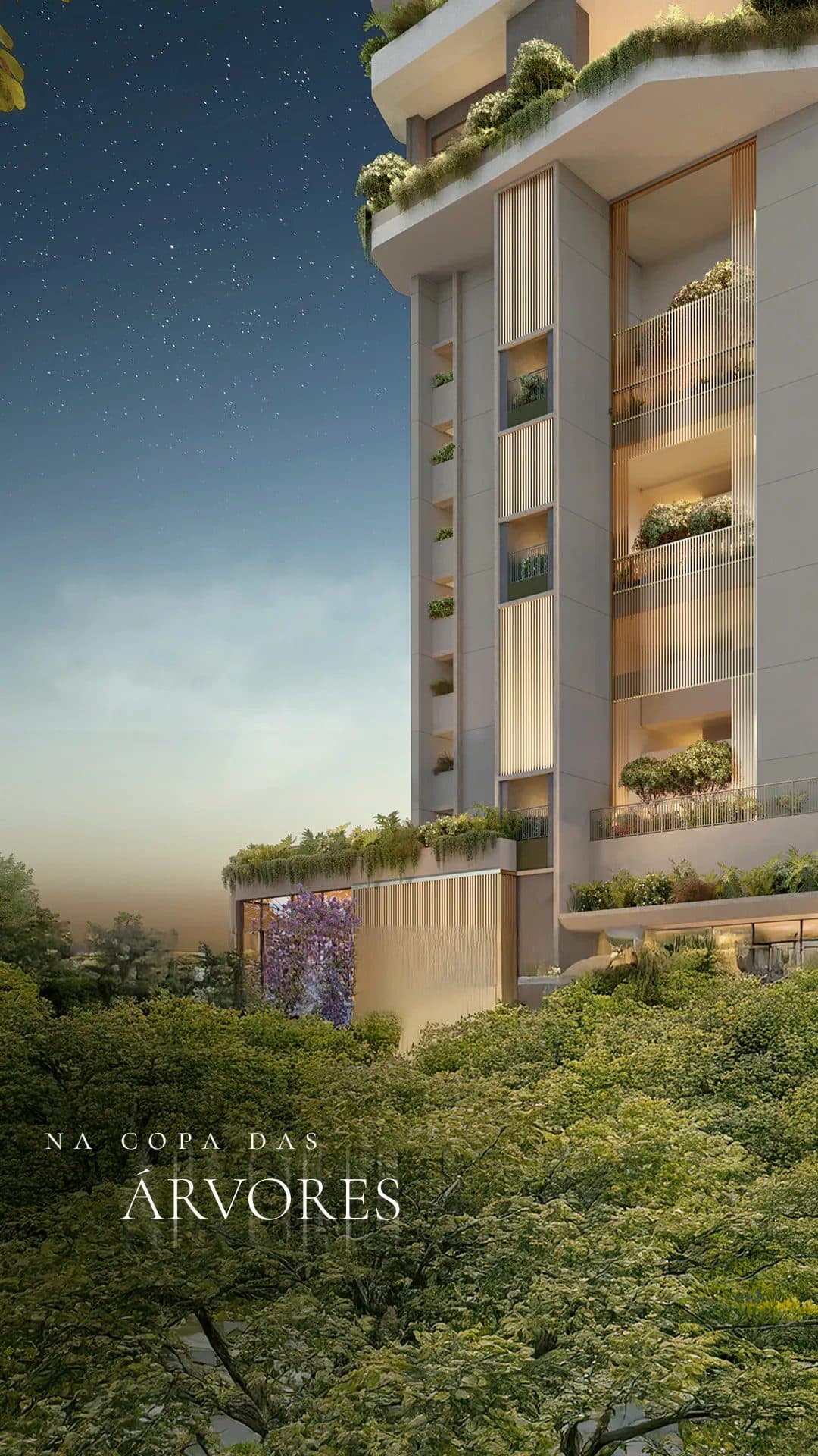 Detalhe da fachada do edifício com vegetação nos terraços e iluminação noturna.
