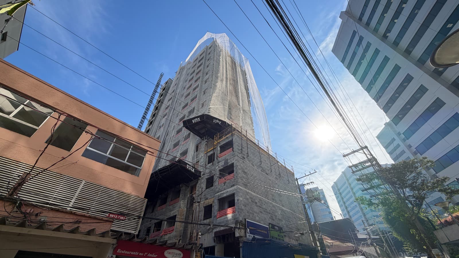 Vista externa da construção do edifício com estrutura em blocos de concreto.