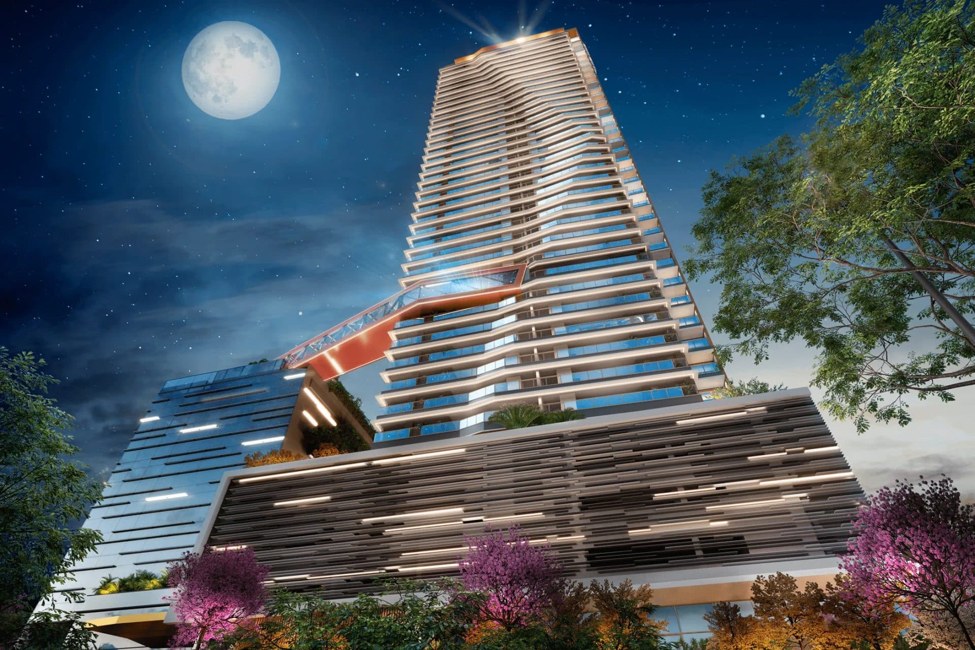 Fachada de edifício residencial moderno à noite com iluminação embutida e árvores na base.