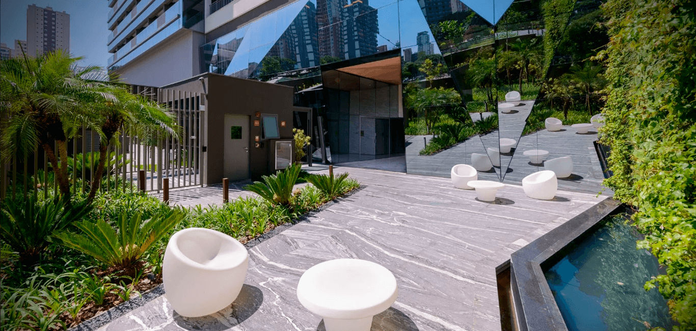 Area externa do condominio com paisagismo, espelho d'agua e mobiliario moderno.