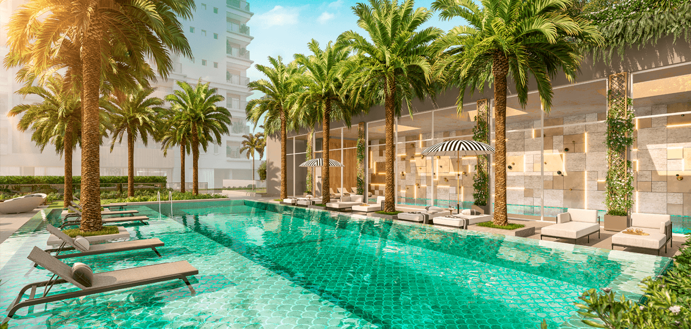 Piscina externa cercada por palmeiras, espreguiçadeiras e paisagismo.