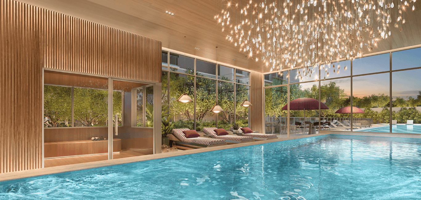 Piscina coberta com grandes janelas de vidro, espreguiçadeiras e sauna ao fundo