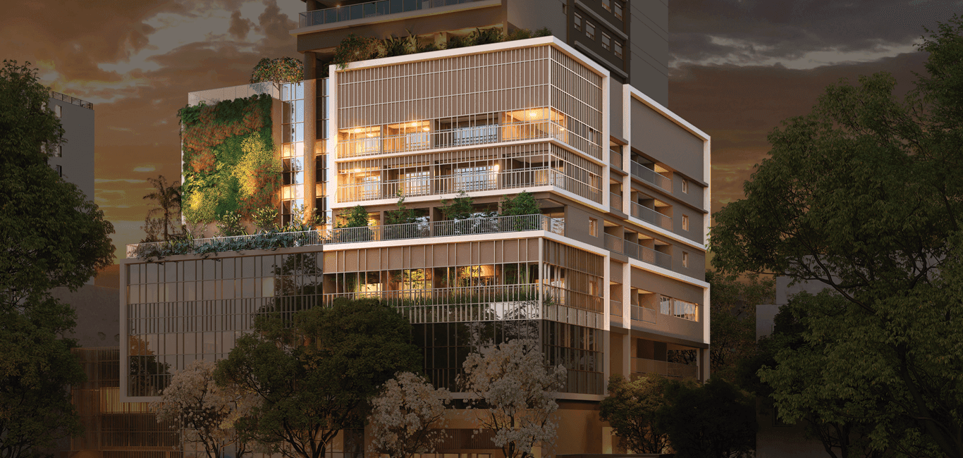 Fachada do edifício noturna com iluminação decorativa, vegetação e amplas janelas